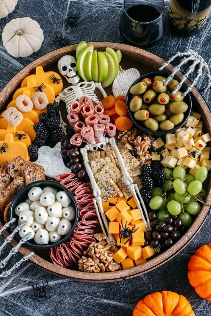 Festive Halloween charcuterie board with spooky treats and decorations