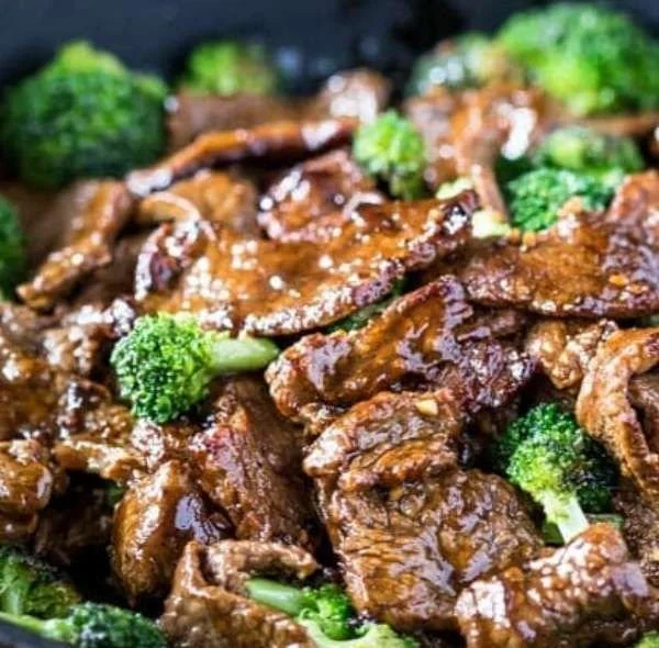 Delicious beef and broccoli stir fry served in a bowl with chopsticks