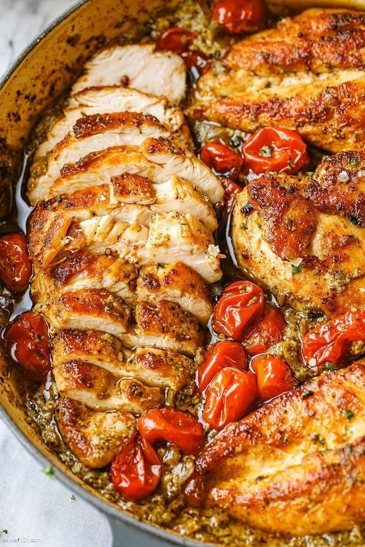 Creamy pesto chicken dish with roasted tomatoes garnished for a delicious meal