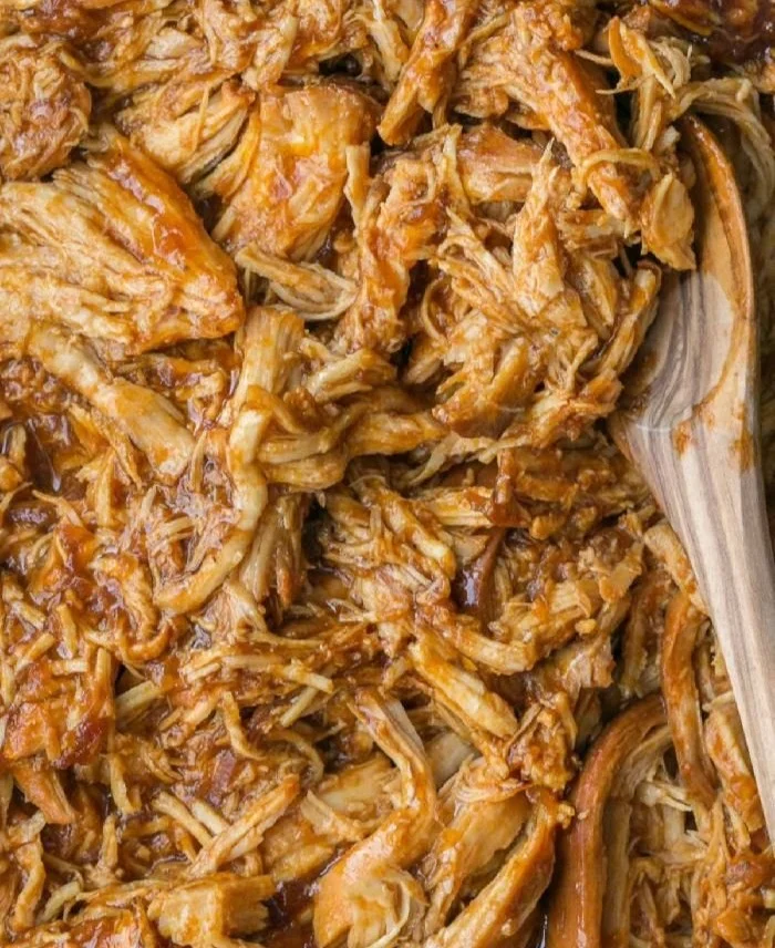 Delicious Crockpot BBQ Chicken served on a plate with fresh herbs and sauce