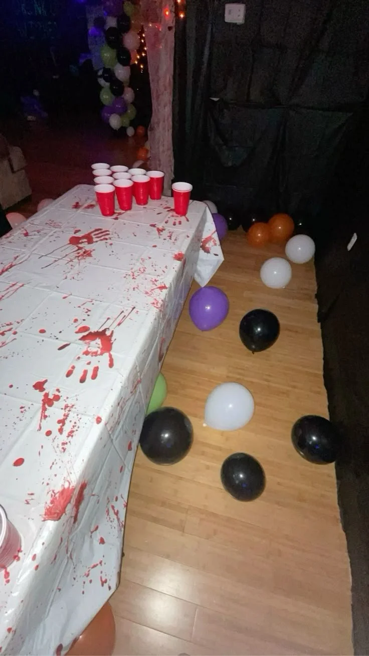 Halloween party cup pong setup with themed decorations and cups