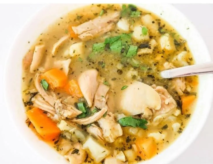 Bowl of homemade anti-inflammatory chicken soup with fresh herbs and vegetables