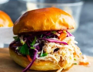 Delicious honey lime shredded chicken sandwich with fresh toppings on a plate