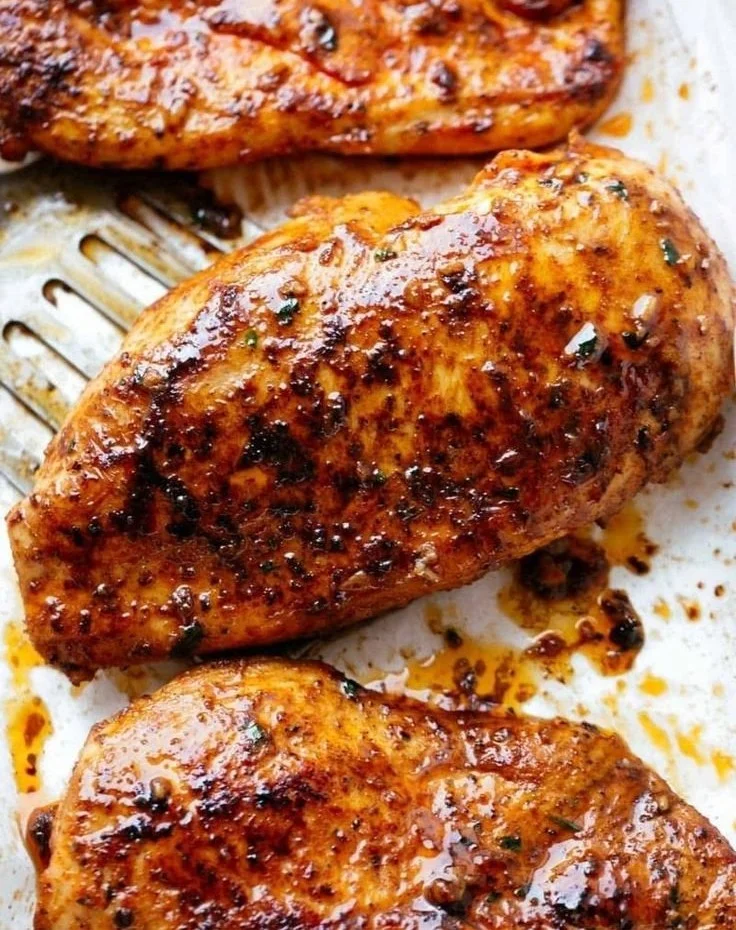 Juicy oven-baked chicken breasts garnished with herbs and spices