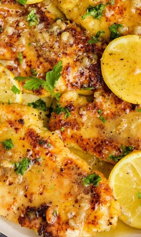 Parmesan-Crusted Lemon Chicken garnished with fresh herbs on a plate