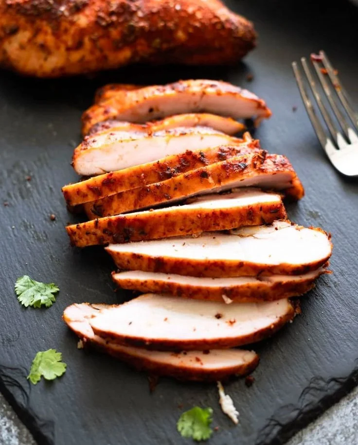 Deliciously smoked chicken breasts ready to be served on a plate.