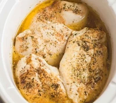 Slow cooker chicken breast in a savory sauce with herbs and spices
