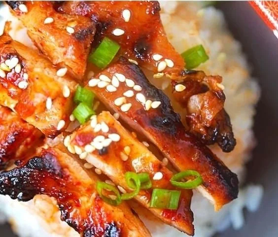 Delicious spicy Korean chicken served on a plate with garnish.