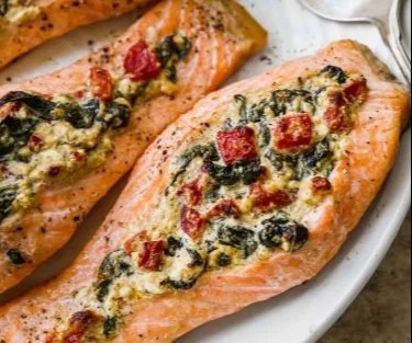 Delicious stuffed salmon fillet with spinach and feta cheese on a plate.