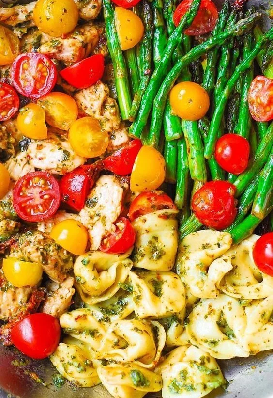 Basil Pesto Chicken served with tortellini, asparagus, and cherry tomatoes
