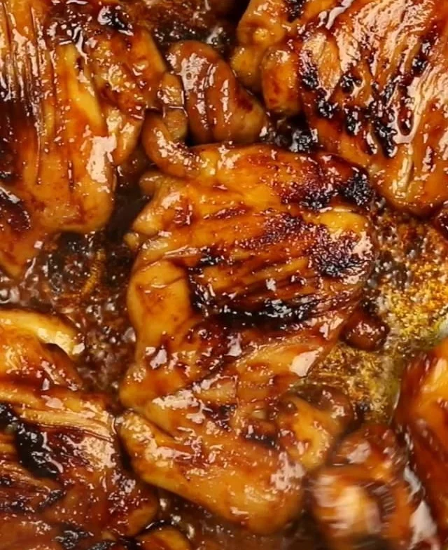 Delicious sweet and spicy glazed chicken thighs served on a plate.