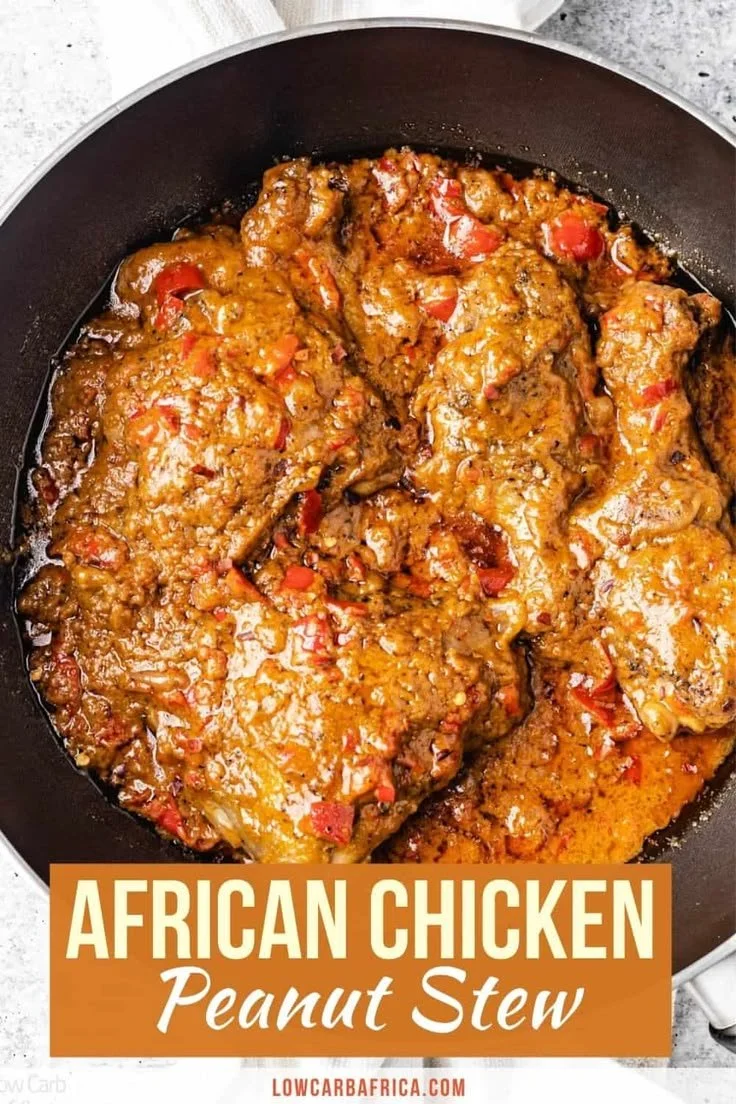 Bowl of African chicken peanut stew with vibrant vegetables and spices.