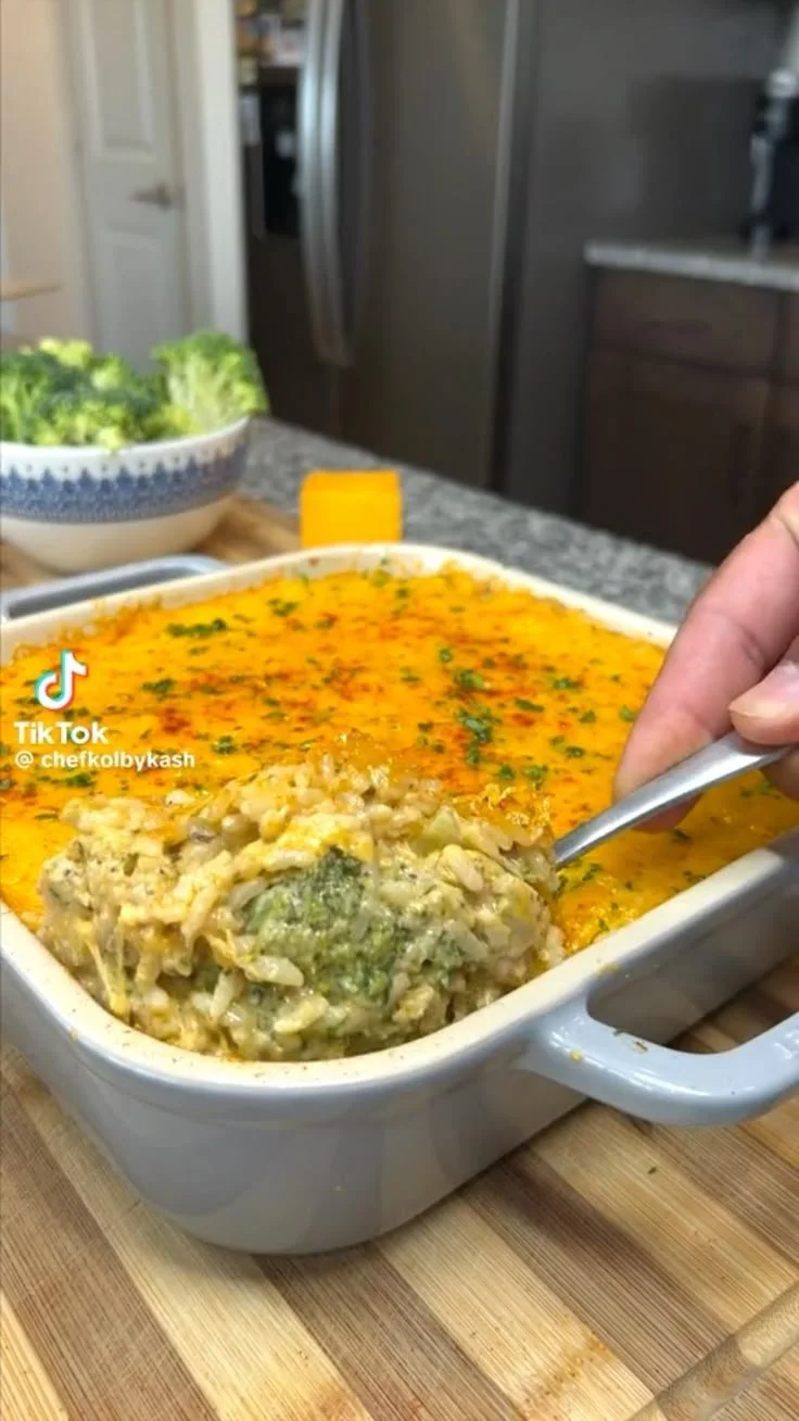 Cheesy chicken broccoli rice casserole served in a dish with broccoli and cheese