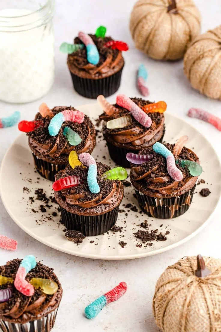 Close-up of dirt cupcakes decorated with gummy worms and chocolate crumbs