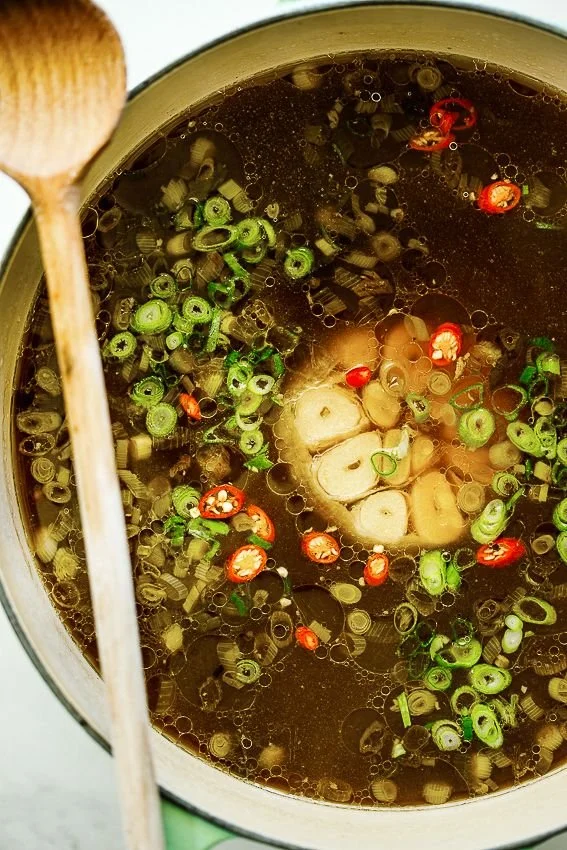 Delicious bowl of easy spicy garlic chicken broth with fresh herbs