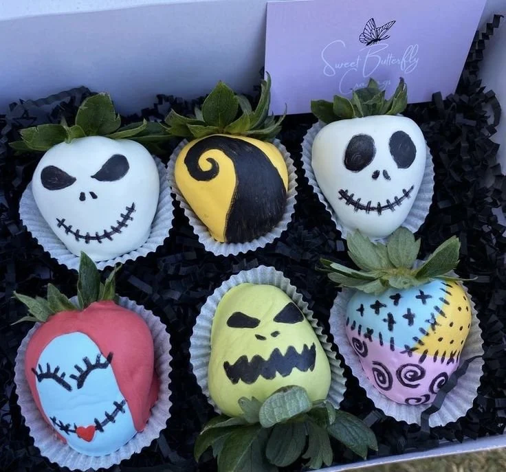 Halloween-themed chocolate covered strawberries inspired by Jack and Sally from Nightmare Before Christmas.