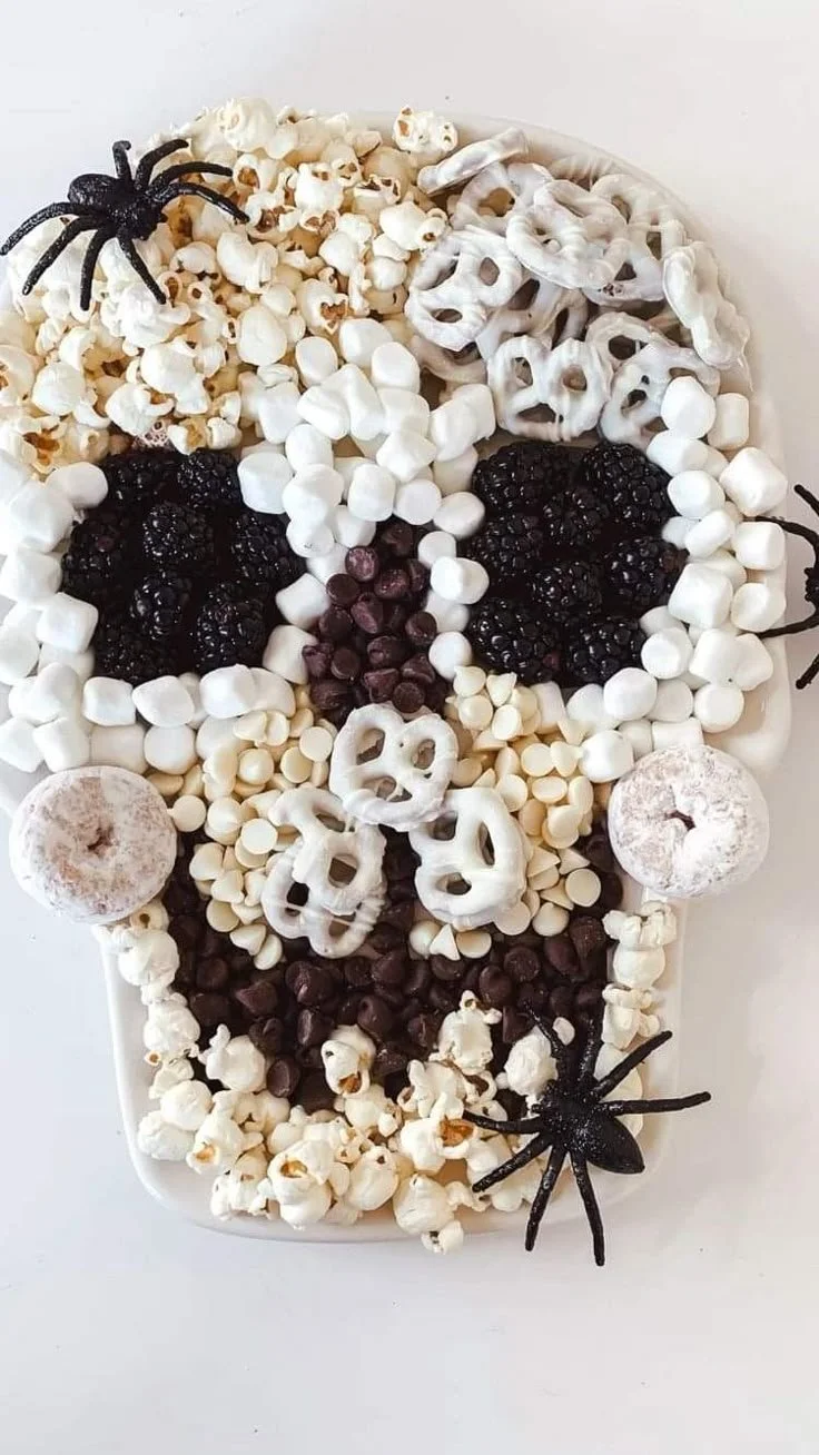 A creative skull-shaped charcuterie board filled with meats and cheeses.