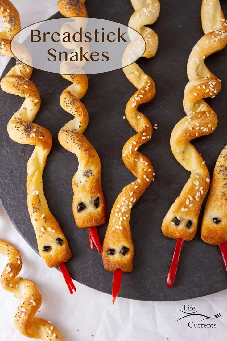 Spooky Halloween breadstick snakes served on a platter for a festive party snack.