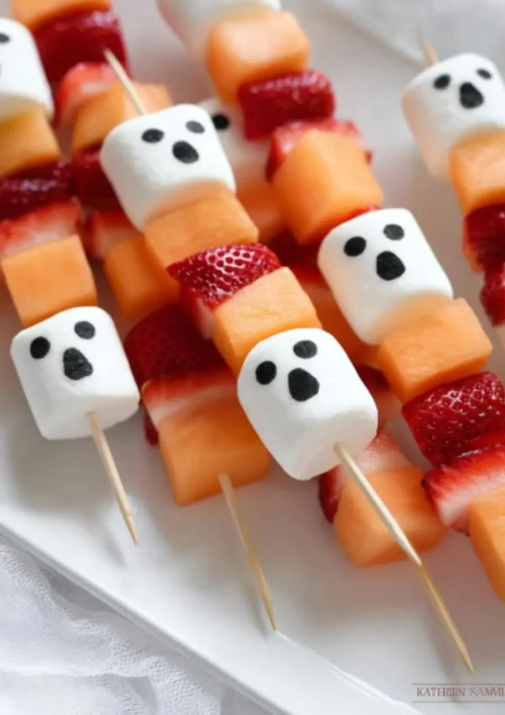 Spooky Halloween ghost fruit kabobs made with assorted fruits for a festive treat